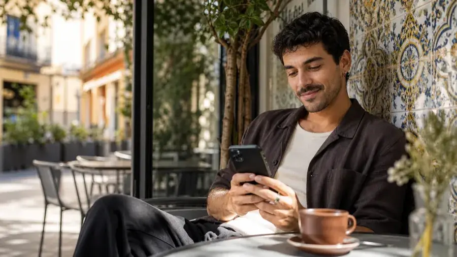 Usuario adulto español gestionando un álbum privado de Menta Social en una cafetería de Madrid